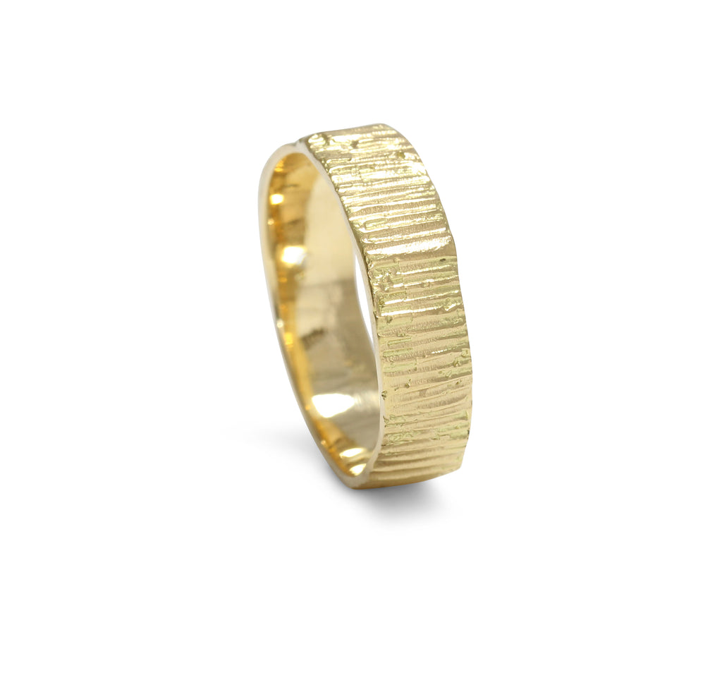 Picture of a textured thick width gold ring band cast from bark into solid gold 